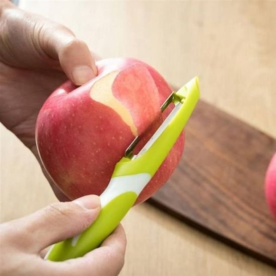 Econome à poignée verte pèle une pomme