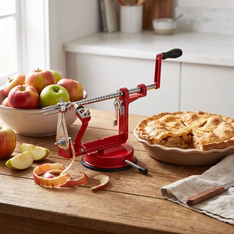 Epluche pomme présentée sur table cuisine avec tarte aux pommes