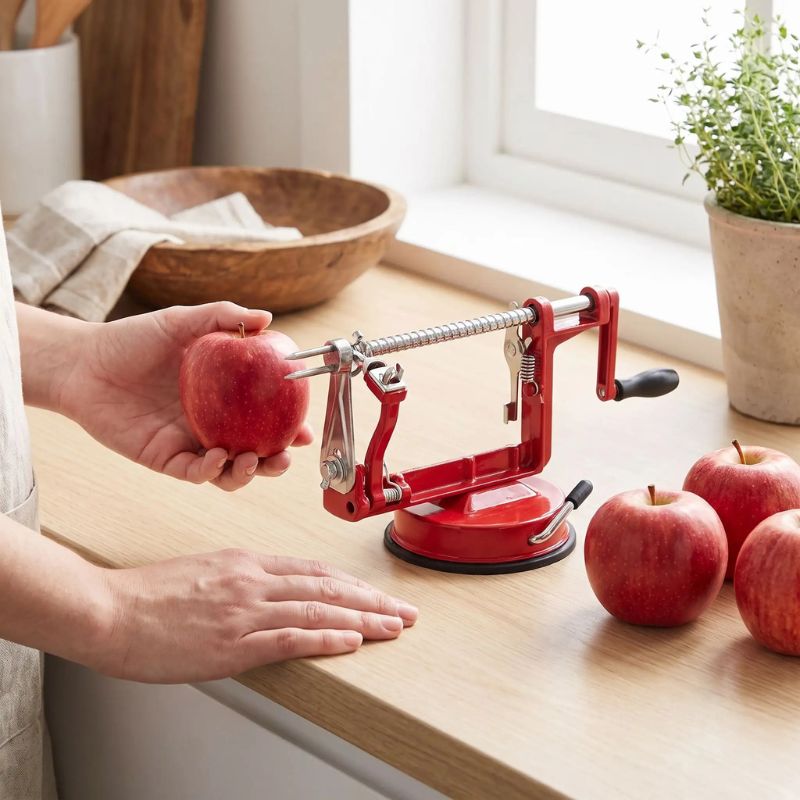 Epluche pomme sur table cuisine avec pommes