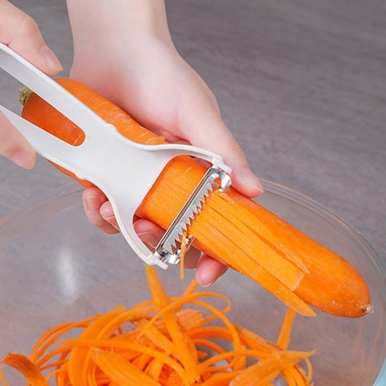 Éplucheur à julienne blanc râpe une carotte