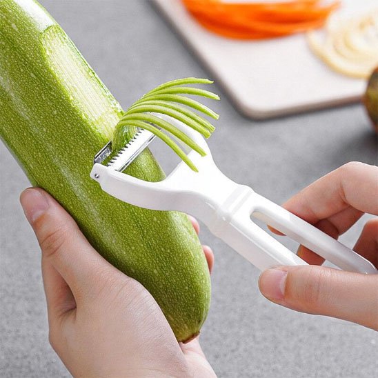 Éplucheur à julienne blanc râpe une courgette