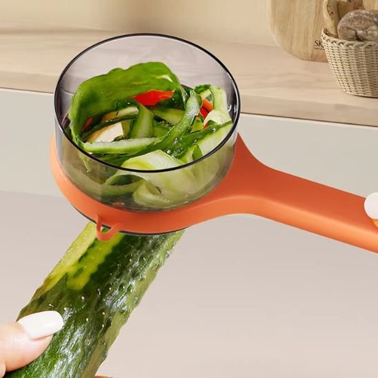 Éplucheur à légumes avec réservoir pelant un concombre