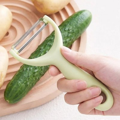 Éplucheur vert clair présenté avec un concombre
