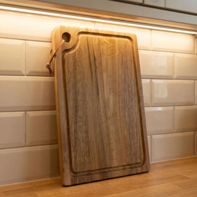 Planche à découper en bois appuyée contre mur cuisine