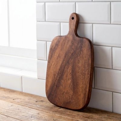 Planche a decouper en bois taille grande inclinée contre mur